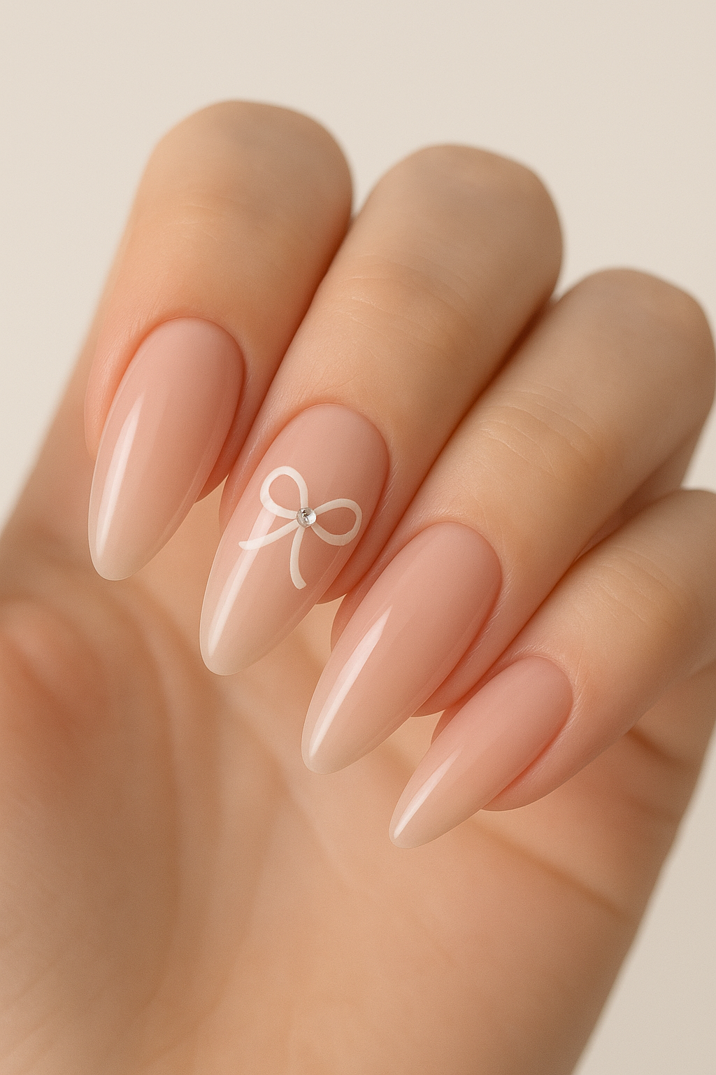 🌸 Elegant Nude Pink Almond Nails with Bow Accent: The Perfect Feminine Manicure